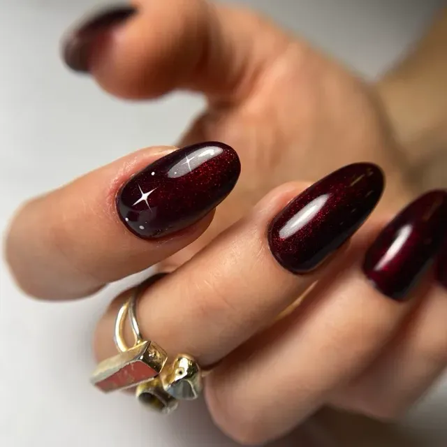 Bordowy manicure cat eye na paznokciach w kształcie migdałów — salon Lua na Polance